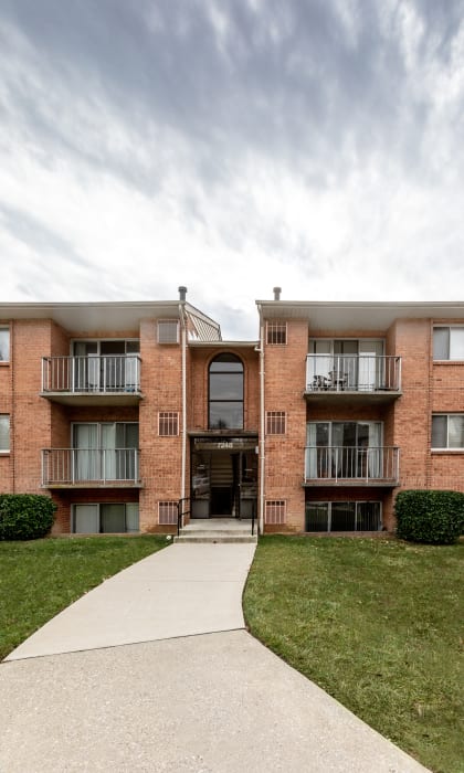 exterior view of a brick apartment building with a sidewalk