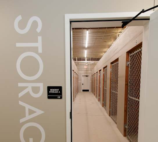 a corridor in a building with a door to a prison cell door