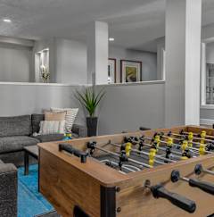 A foosball table is in the middle of a living room.