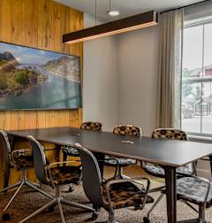 a conference room with a table and chairs and a large window