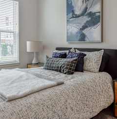 a bedroom with a bed and a dresser and a window