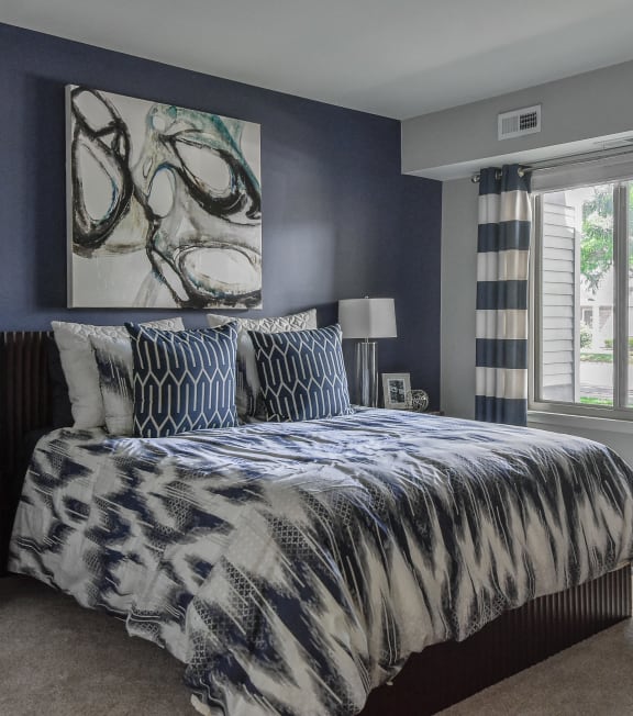 a bedroom with a bed and a painting on the wall