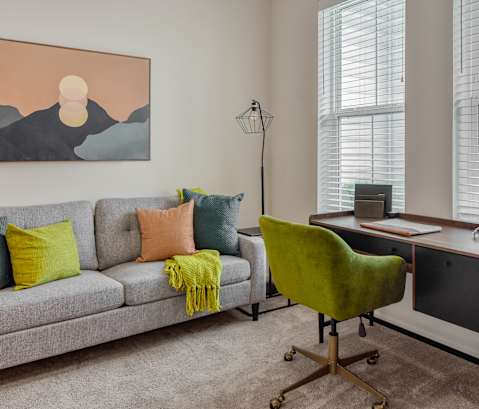 a living room with a couch and a desk with a chair