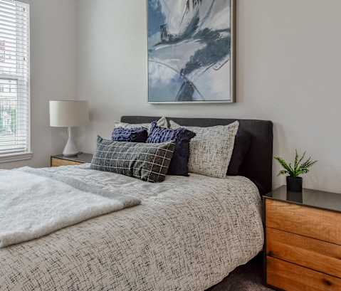 a bedroom with a bed and a dresser and a window