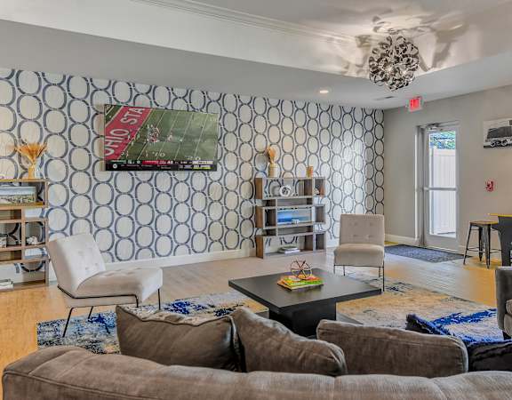 a living room with couches and chairs and a tv