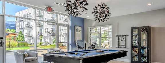 a games room with a pool table and a large window