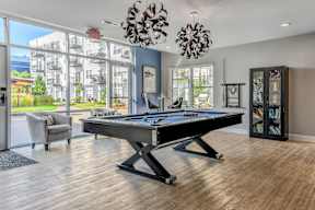 a games room with a pool table and a large window