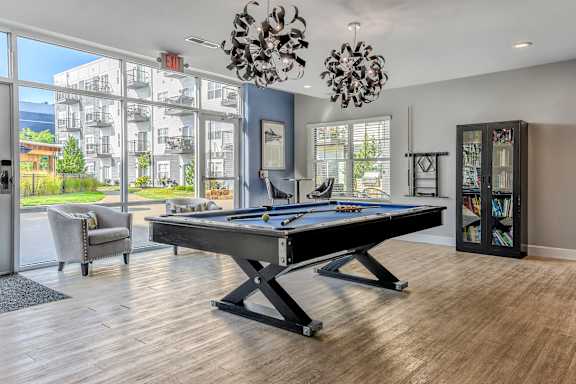 a games room with a pool table and a large window
