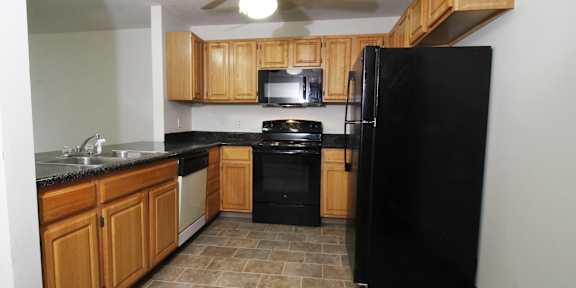 a kitchen with wooden cabinets and white appliances