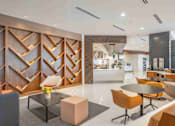 Thumbnail 12 of 24 - A modern dining area with a glass table and orange chairs.