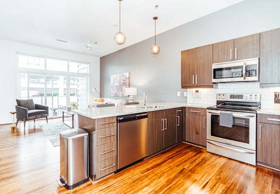 a large kitchen with wooden floors and stainless steel appliances at 20 Midtown, Birmingham, 35233