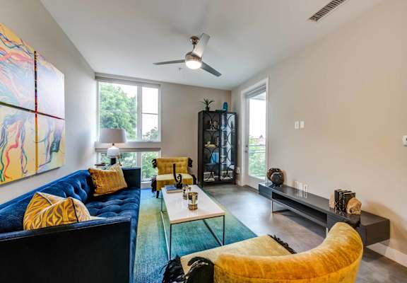 A living room with a blue couch and a yellow chair.