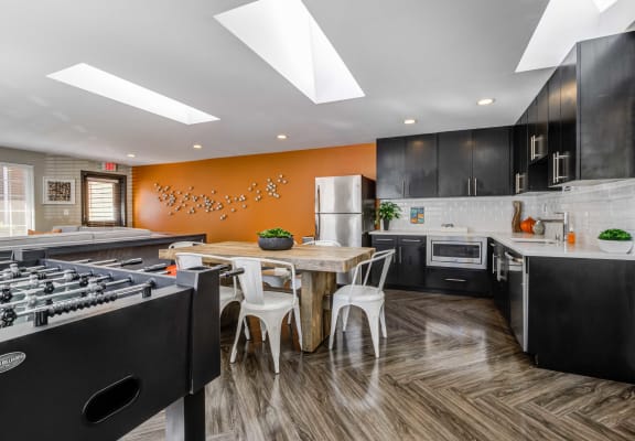 a kitchen with black cabinets and an orange accent wall