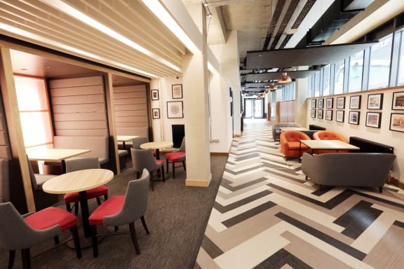 a large room with tables and chairs and a chevron floor