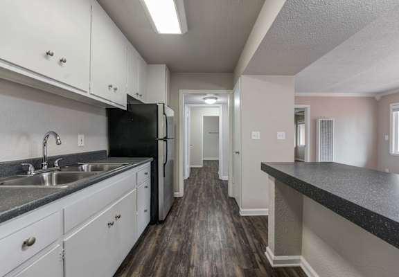 a kitchen with white cabinets and black appliances