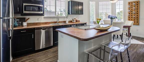 a kitchen with a large island and stainless steel appliances
