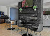 Thumbnail 5 of 5 - A black table with four chairs in front of a fireplace.
