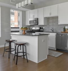 a kitchen with a center island and two stools at Park 205, Park Ridge, 60068