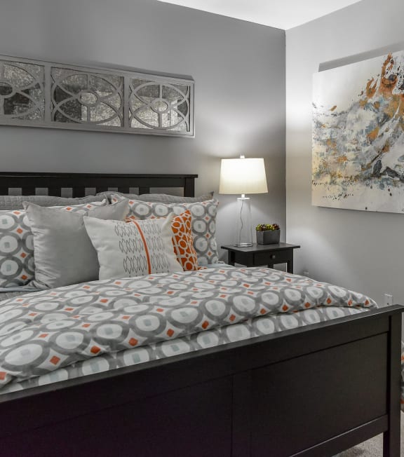 a bedroom with a bed and a door to a bathroom at The Villas at Main Street, Ann Arbor, MI, 48103