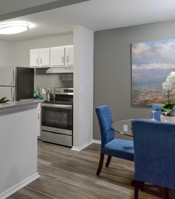a kitchen and a dining room with a table and chairs at The Villas at Main Street, Ann Arbor, Michigan