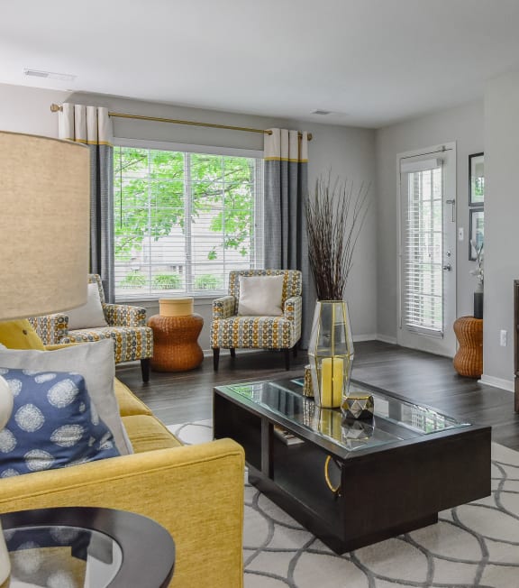 a living room with furniture and a large window at The Villas at Main Street, Ann Arbor, Michigan