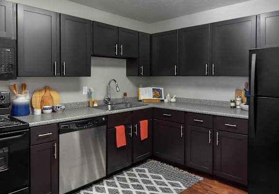 full kitchen with black cabinets and stainless steel appliances at The Pointe at St. Joseph Apartments, Indiana