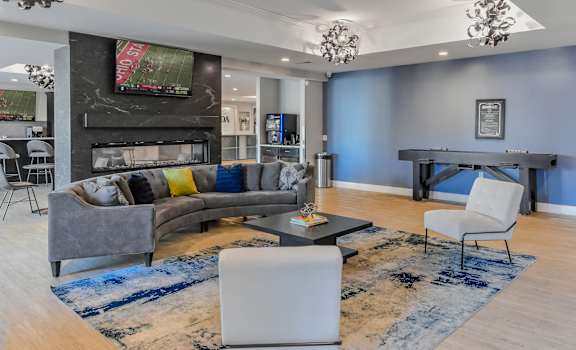 a living room with blue walls and a gray couch and a table and chairs