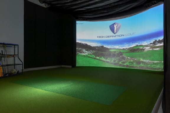 a room with a green carpet and a projector screen on the wall