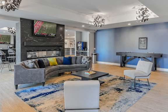 a living room with blue walls and a gray couch and a table and chairs