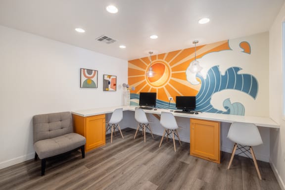 a room with a desk and chairs and a mural on the wall