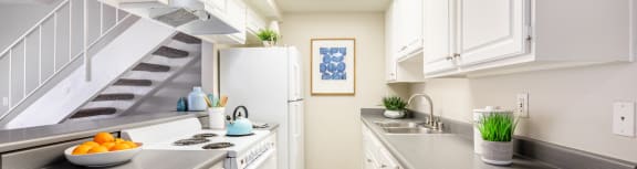 a kitchen with white cabinets and a white stove top oven