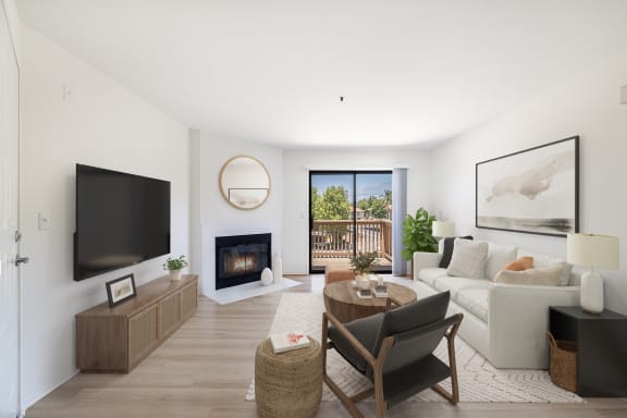 a living room with white walls and a white couch with a wooden coffee table and black chair