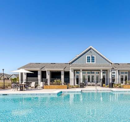 Large swimming pool with Outpost Orchard Clubhouse in the background.