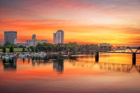 the city at sunset with a bridge over the water