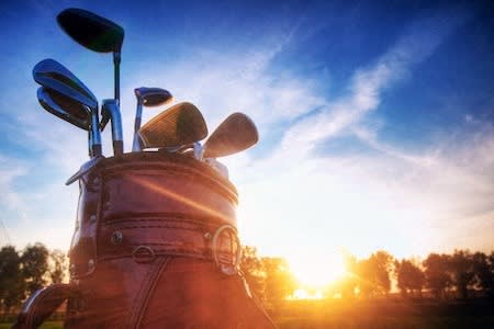 a bag of golf clubs with the sun in the background