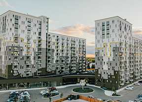 Apartment buildings with a parking lot in front of them.
