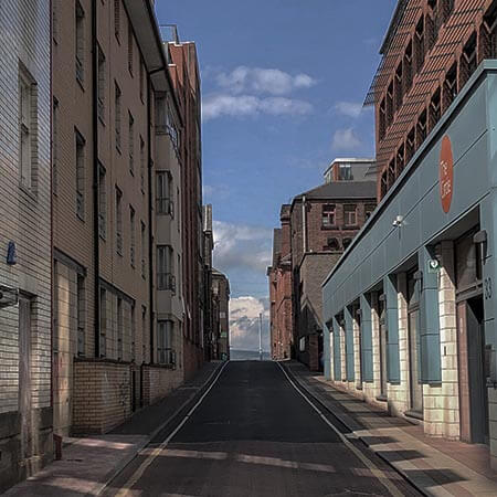 an empty street with tall buildings on both sides of it