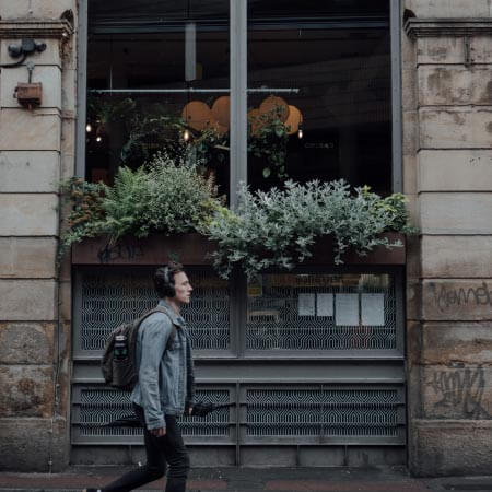 a man walking down the street in front of a store