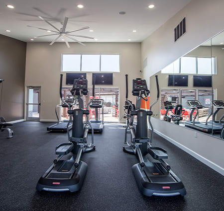 a gym with treadmills and ellipticals