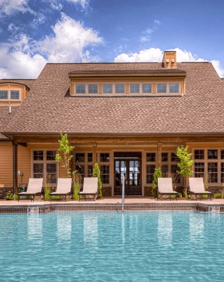 A house with a pool in front of it.