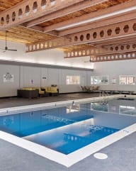 a large pool in a large room with a wooden ceiling