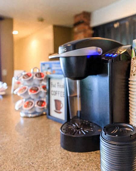 a coffee maker on a counter next to a coffee cup