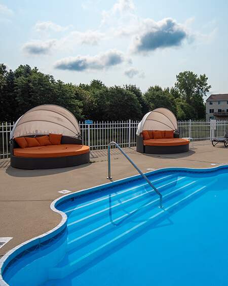 Swimming pool with lounge chairs at Bloomfield Townhomes