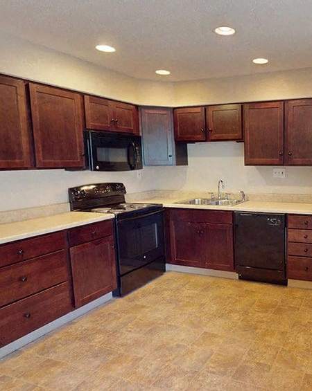 a kitchen with wooden cabinets and a stove and a sink
