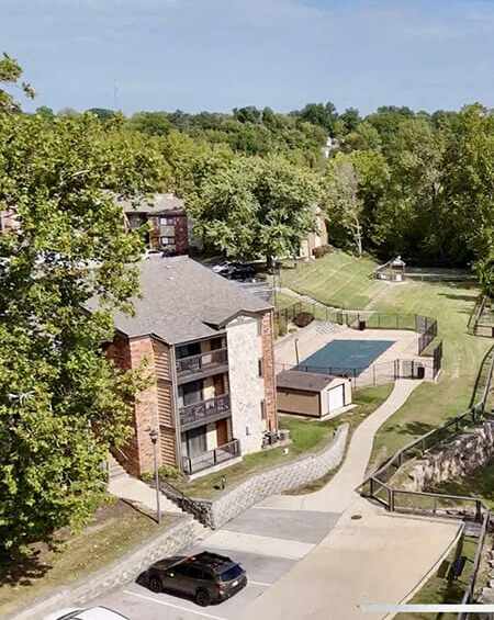 an aerial view of an apartment building and a tennis court