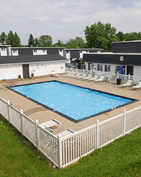a resort style swimming pool in front of a house