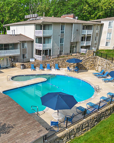 a swimming pool with umbrellas and chairs in front of a building