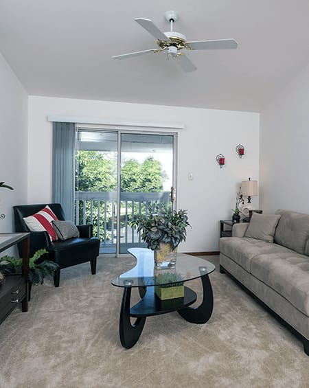 a living room with a couch and a table and a ceiling fan