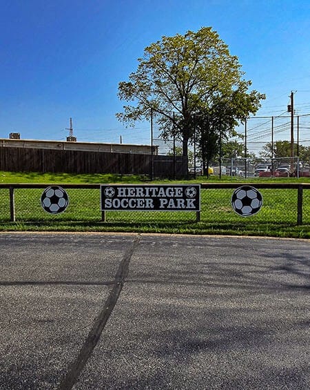 a soccer park sign on the side of a road
