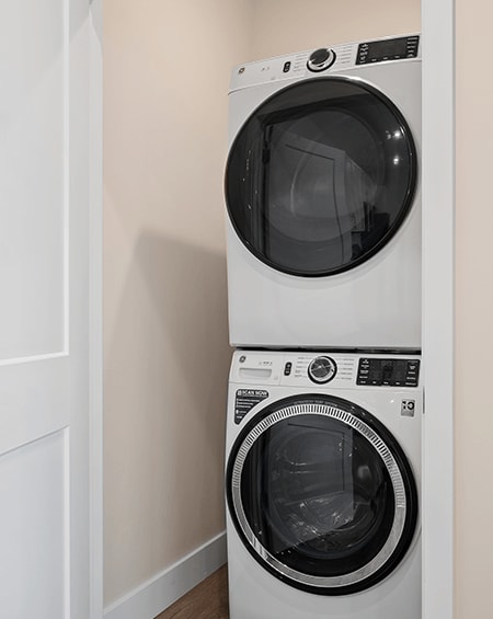 Two white front loading washing machines in a laundry room.